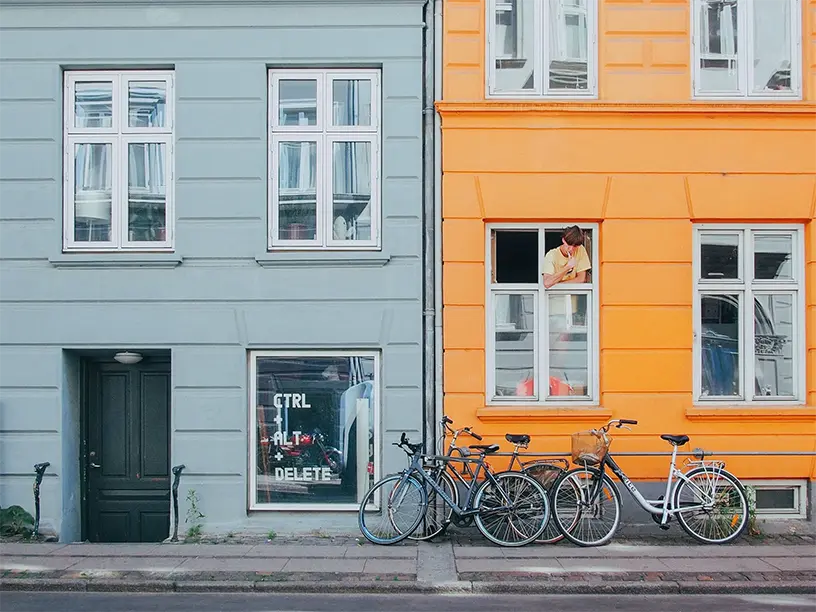To cykler parkeret foran en bygning.