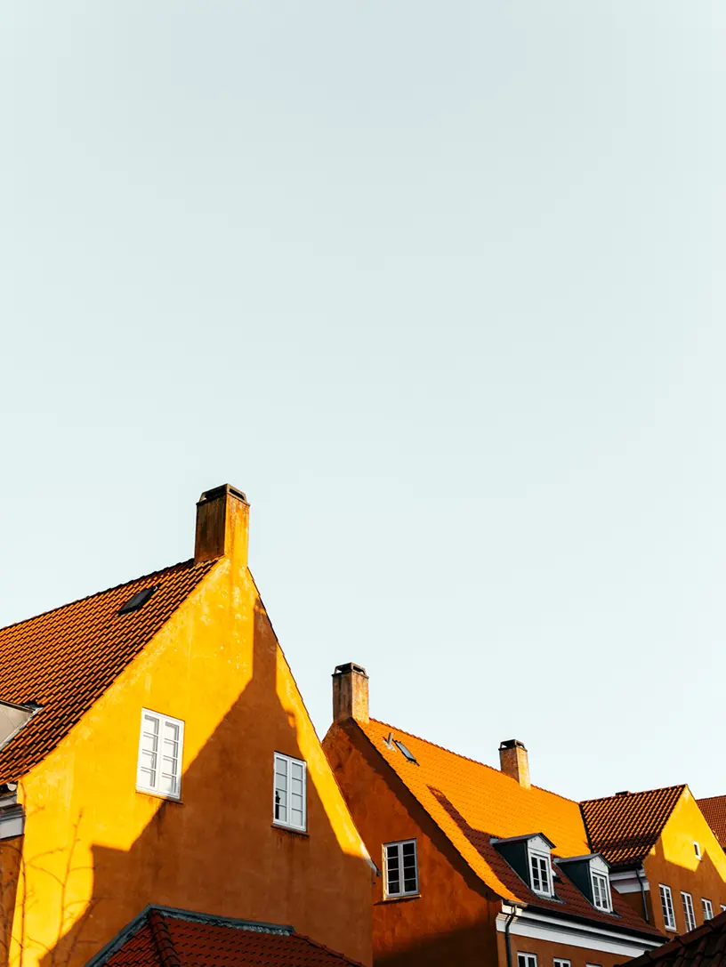 En række huse med en blå himmel i baggrunden med boliglånsfinansiering.