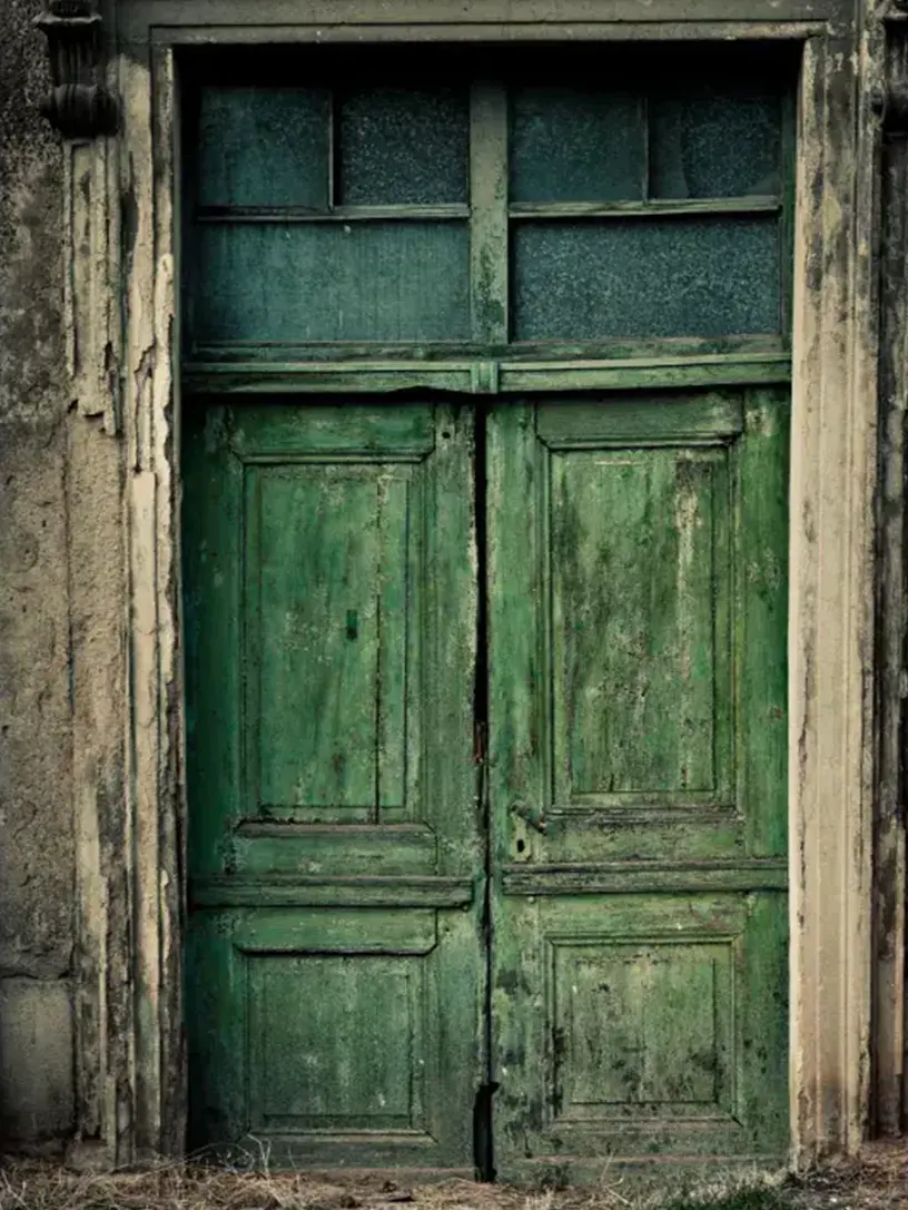 En gammel grøn dør i en gammel bygning med boliglån beregner.