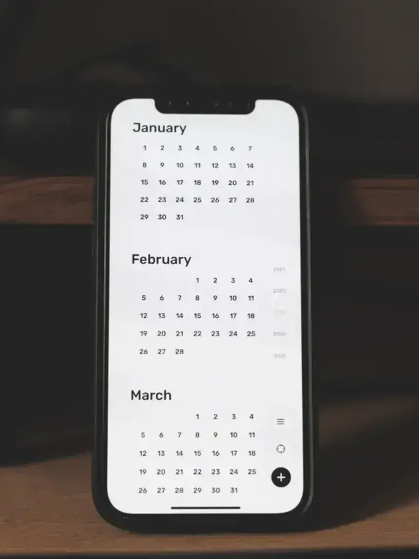 En telefon med en kalender på står på et skrivebord, der bruges til at administrere huslån.