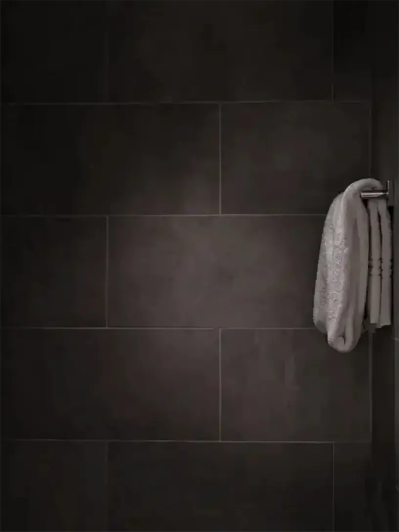 Et håndklæde hænger på en håndklædestativ i et friværdifyldt badeværelse.