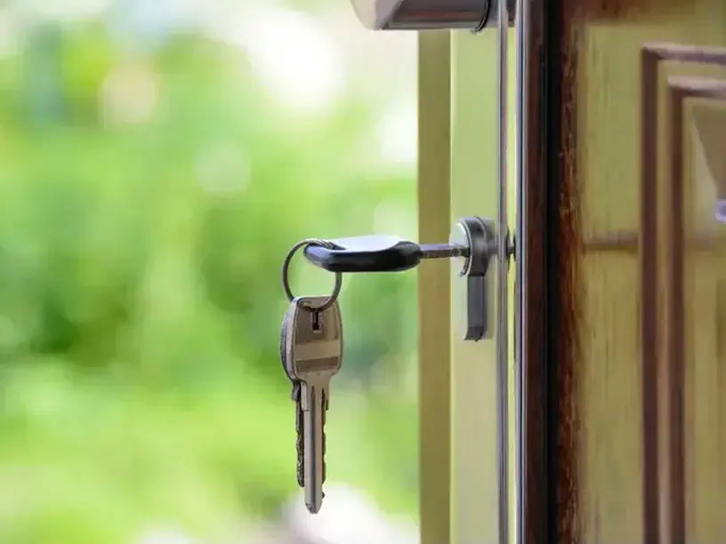 En nøgle er uden om banken fastgjort til døren til et hus.