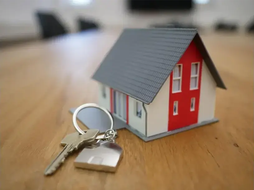 En model af et Pantebrevslaan-hus med nøgler på et bord.